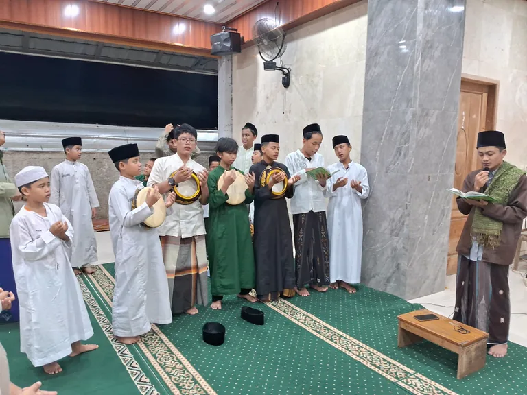 Santri berkegiatan bersama sambil memainkan rebana dan membaca buku.