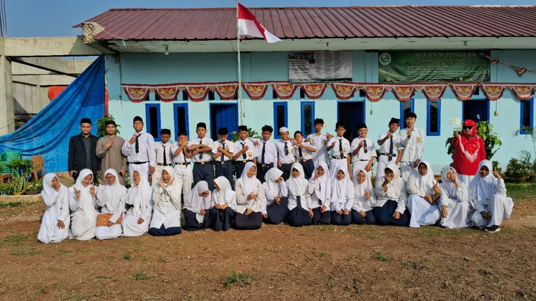 Siswa dan pendamping berfoto bersama di depan bangunan pondok pesantren.