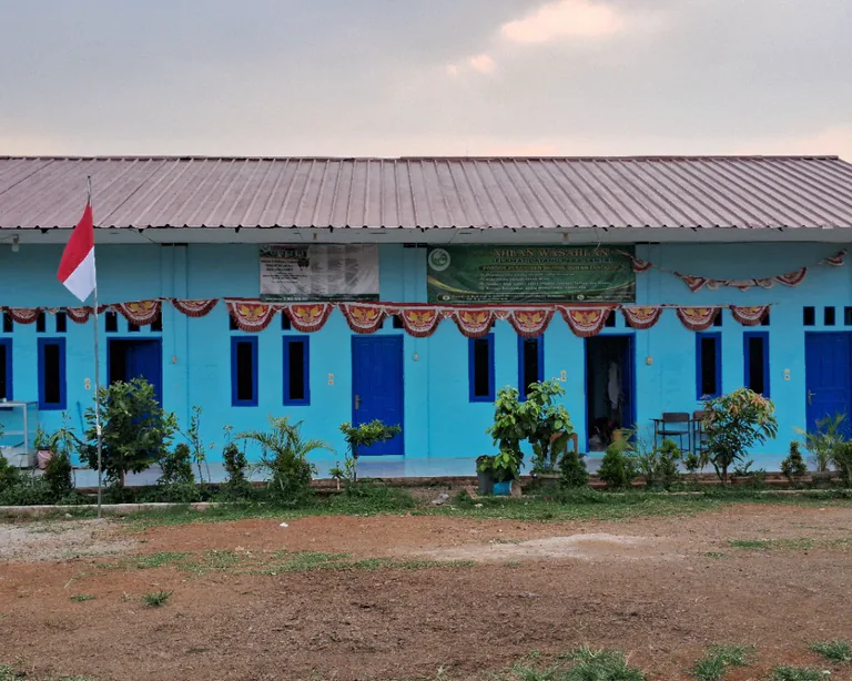 Bangunan biru Pondok Pesantren Daarul Quran Fantastis Pusat dan halaman di depannya.
